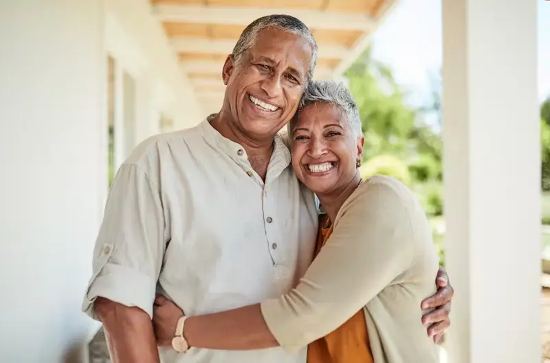 Smiling mature couple embracing outdoors, representing health, happiness, and well-being